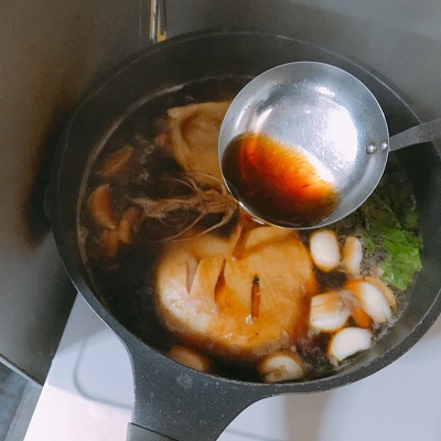 煮汁をかける鳥足のナンプラー煮