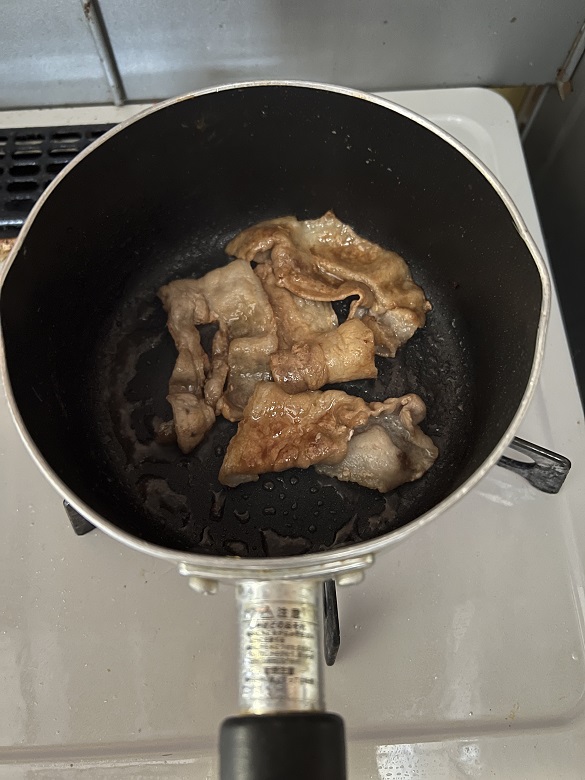味付けした豚バラを焼く